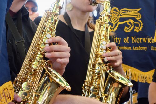 Students play saxophones at live event