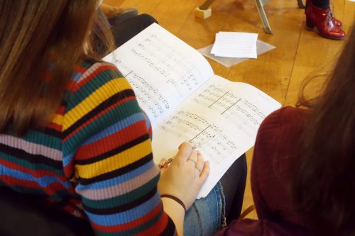 Student looking at book of sheet music